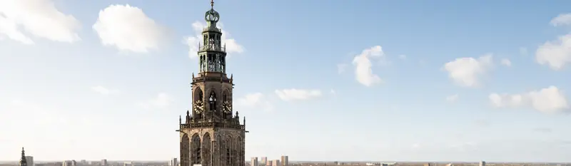 De Martinitoren boven de daken van Groningen, met de skyline van de stad aan de horizon